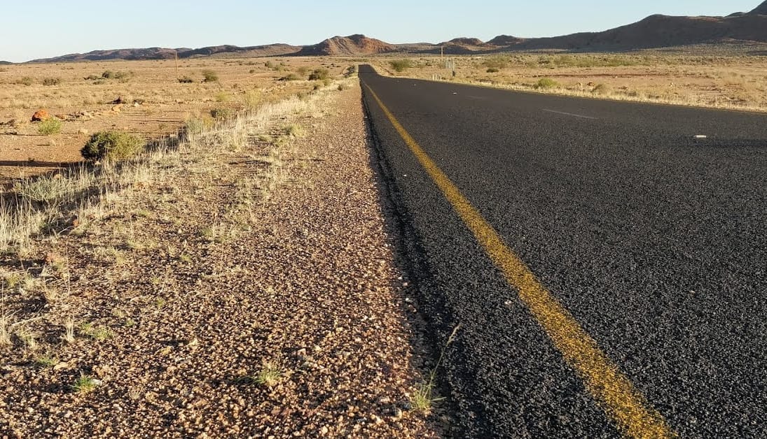 From the Northern Cape in South Africa. A very straight road that just keeps going into the distance, with rolling hills in the background.